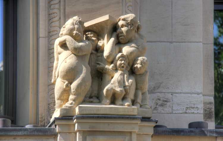 Geschäftshaus, Köln. An der Fassade befinden sich Skulpturen, die Szenen aus der Märchen »Des Kaisers neue Kleide« darstellen. Quelle: Wikipedia